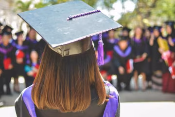 Una ragazza uscita dalla propria festa di laurea universitaria.